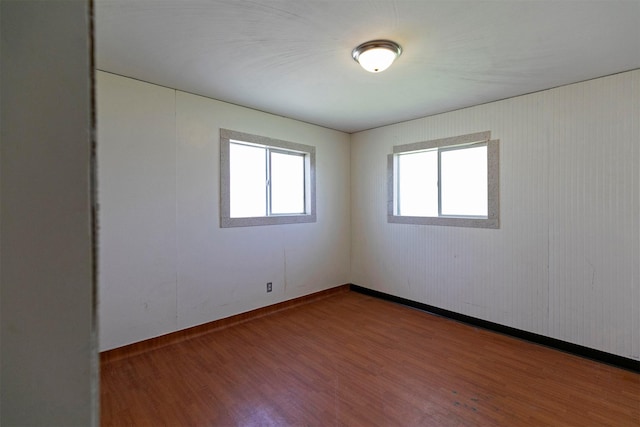 unfurnished room featuring baseboards and wood finished floors