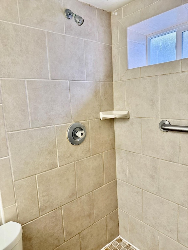 full bath with a tile shower and toilet