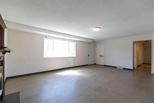 unfurnished room featuring tile patterned floors, baseboards, a textured ceiling, and visible vents