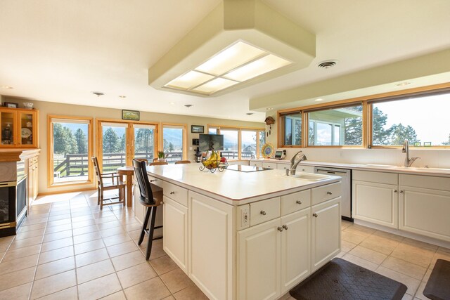 34051 Ridge Rd, Polson, MT 59860 - kitchen with stainless steel dishwasher, a sink, a kitchen island with sink, and light tile patterned floors