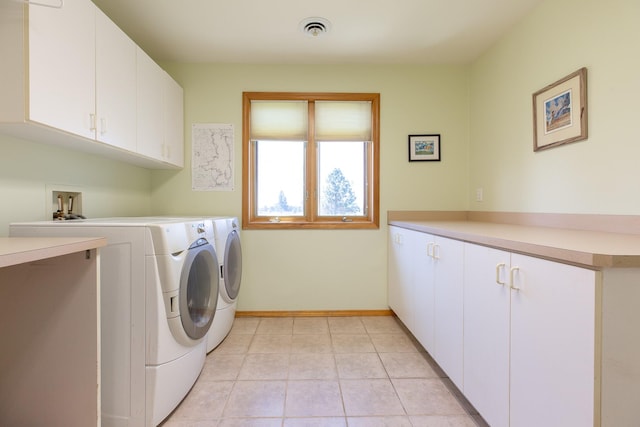 34051 Ridge Rd, Polson, MT 59860 - laundry area with independent washer and dryer, visible vents, cabinet space, light tile patterned floors, and baseboards