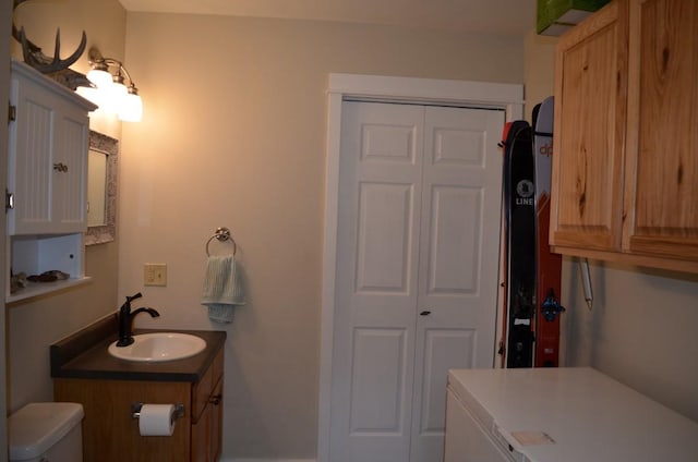 bathroom featuring a closet, toilet, and vanity