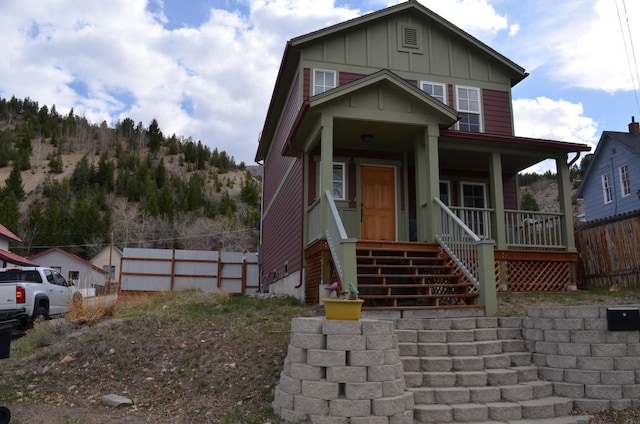 view of front of property with fence, covered porch, and board and batten siding