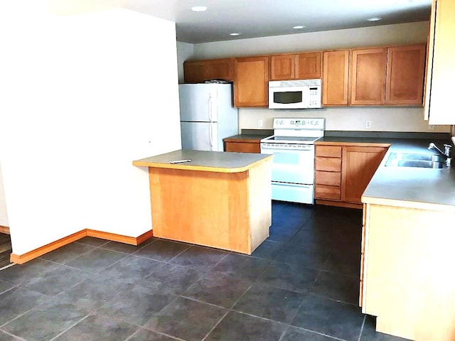 kitchen featuring a sink, baseboards, a peninsula, recessed lighting, and white appliances