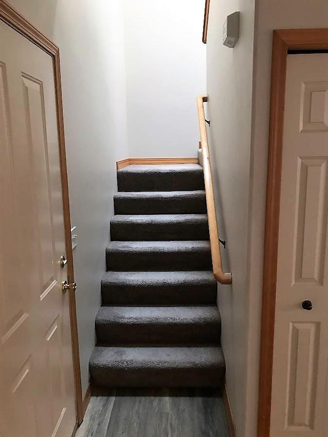 staircase featuring baseboards and wood finished floors