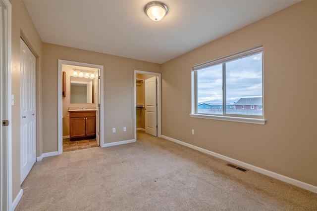 817 Vega Rd, Helena, MT 59602 - unfurnished bedroom featuring ensuite bath, light colored carpet, visible vents, and a closet