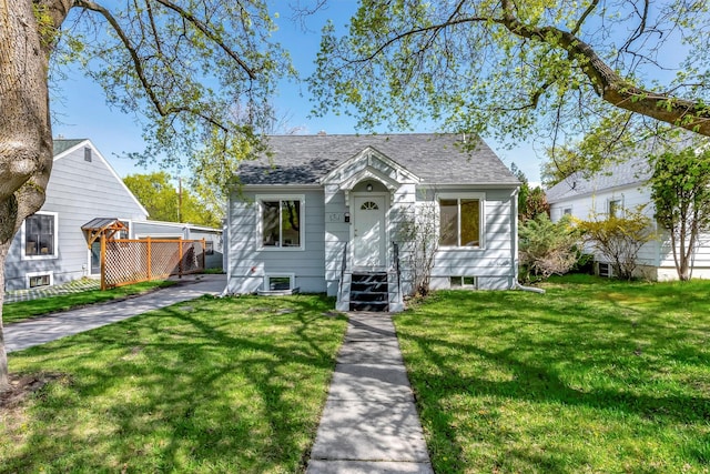 bungalow-style home featuring a shingled roof and a front lawn