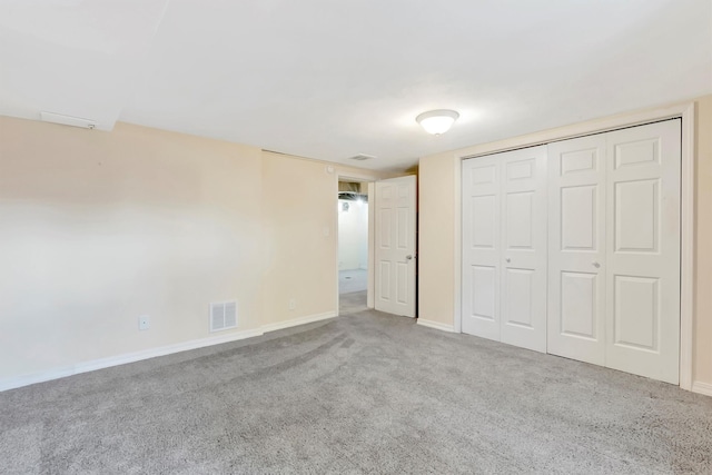 unfurnished bedroom featuring baseboards, visible vents, carpet, and a closet