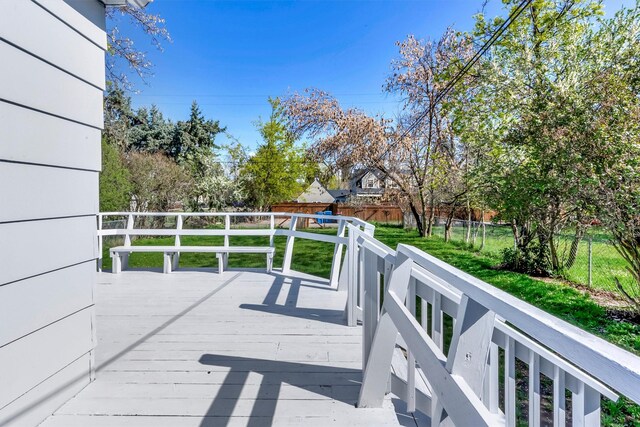 wooden terrace with a yard and a fenced backyard