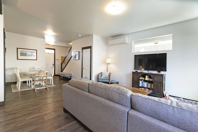living area with dark wood-style flooring and an AC wall unit
