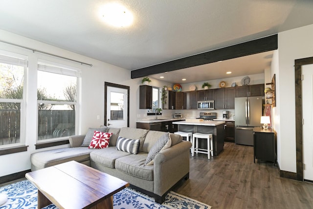 living area with recessed lighting, baseboards, beamed ceiling, and dark wood finished floors