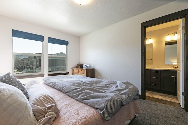 carpeted bedroom featuring a sink and connected bathroom