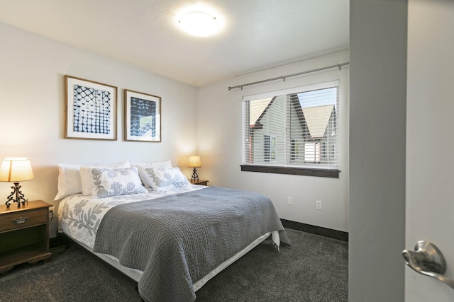 bedroom featuring baseboards and dark colored carpet