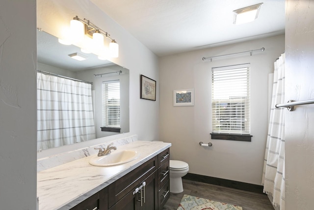 full bath featuring vanity, wood finished floors, curtained shower, toilet, and baseboards