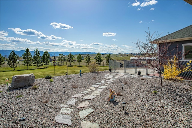 view of yard with fence, a gate, and a mountain view