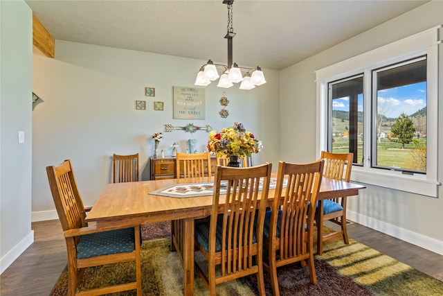 dining room featuring baseboards, dark wood-style floors, and a chandelier