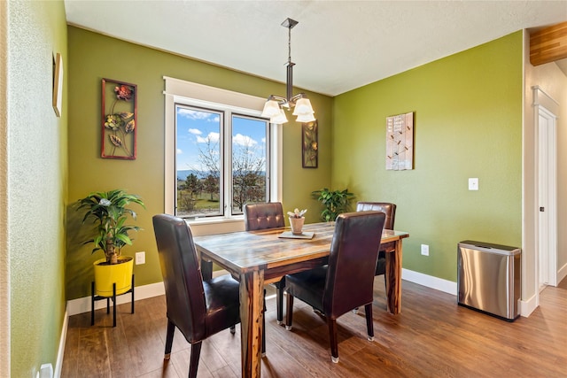 dining area with an inviting chandelier, baseboards, and wood finished floors