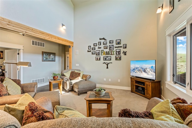 living room featuring baseboards, visible vents, carpet, and a towering ceiling