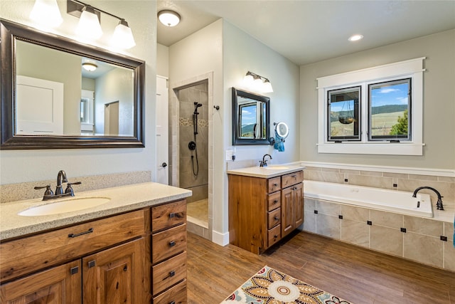 bathroom with a sink, tiled shower, and wood finished floors