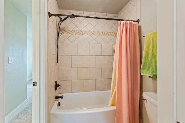 bathroom featuring toilet, a textured wall, shower / bathtub combination with curtain, and baseboards