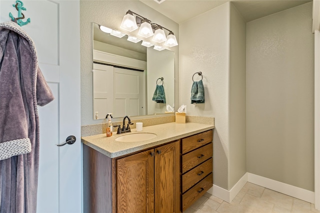 bathroom featuring vanity, baseboards, and tile patterned floors
