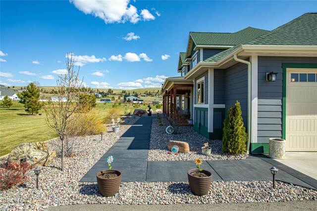 view of property exterior with a garage and roof with shingles