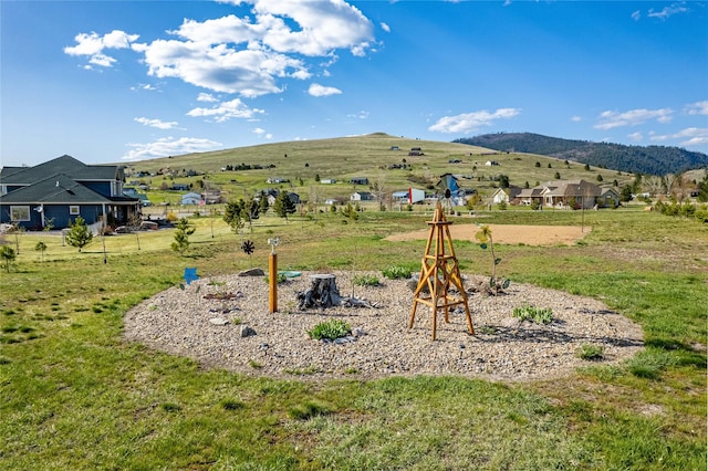 view of playground featuring a lawn and a mountain view