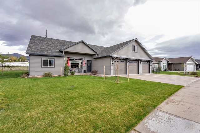 view of front facade featuring fence, concrete driveway, a front lawn, and a garage