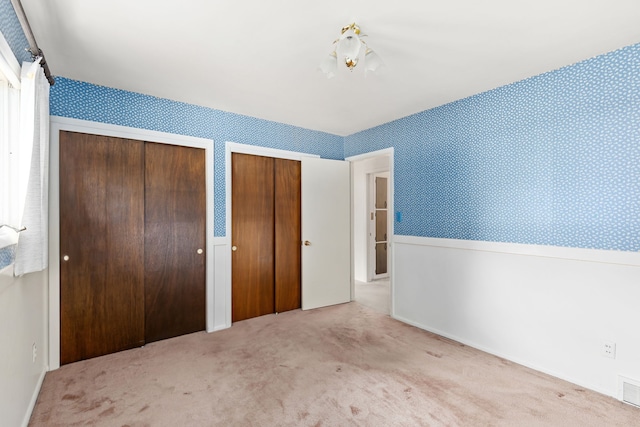 416 Riverview Dr E, Great Falls, MT 59404 - unfurnished bedroom featuring multiple closets, wallpapered walls, and carpet floors