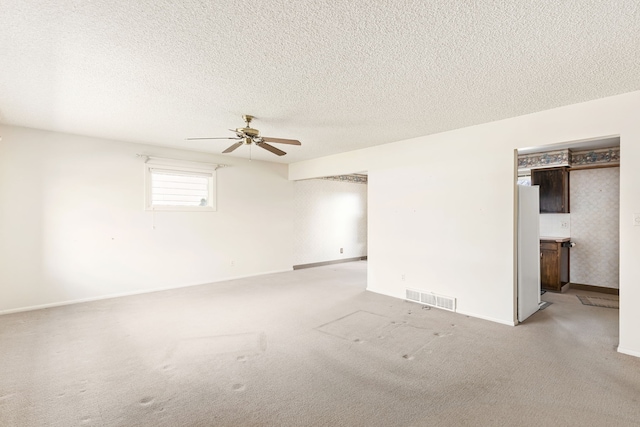 416 Riverview Dr E, Great Falls, MT 59404 - empty room with visible vents, baseboards, light colored carpet, a textured ceiling, and a ceiling fan