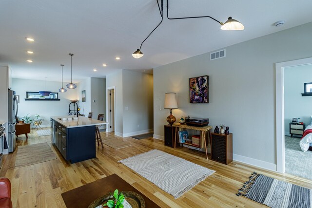 living room with visible vents, recessed lighting, baseboards, and light wood-type flooring