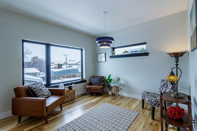 sitting room featuring baseboards, visible vents, and wood finished floors