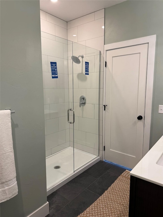 bathroom with tile patterned floors, a shower stall, and vanity