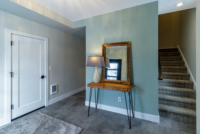 interior space with baseboards, visible vents, and stairway