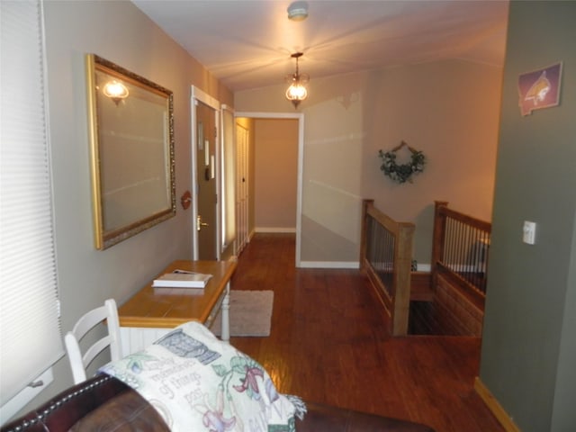 corridor with baseboards and wood finished floors