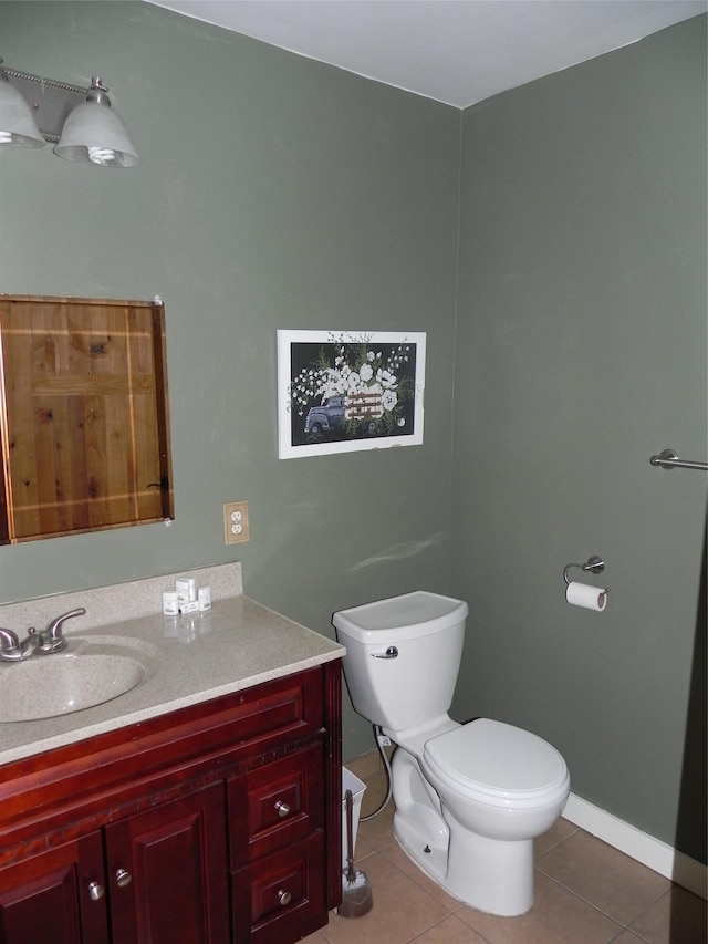 bathroom featuring toilet, tile patterned floors, baseboards, and vanity