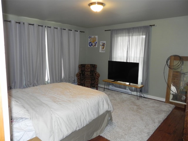 bedroom with baseboards and wood finished floors