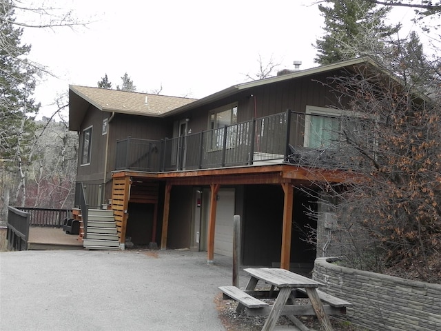back of property with a wooden deck and stairway