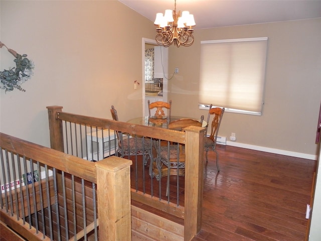 dining area featuring baseboards, wood finished floors, and a chandelier