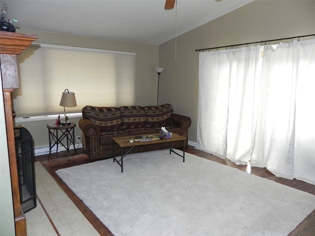 living room with ceiling fan, wood finished floors, and lofted ceiling