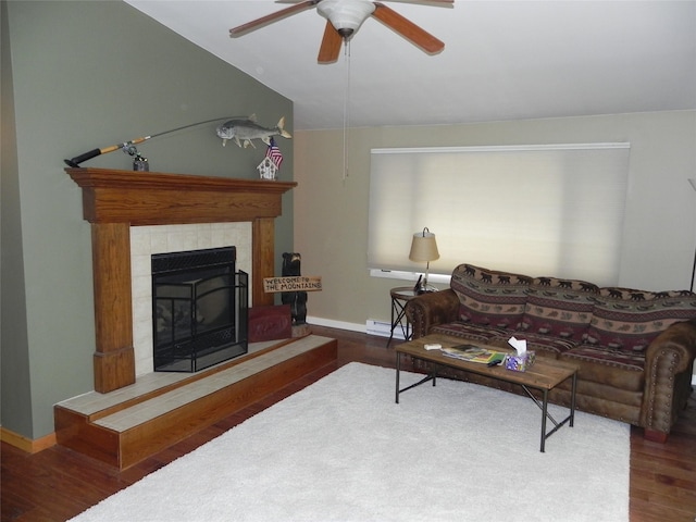 living room with a fireplace, a ceiling fan, baseboards, wood finished floors, and a baseboard heating unit
