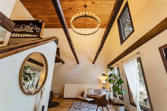 interior space featuring an inviting chandelier, beam ceiling, high vaulted ceiling, wooden ceiling, and wood finished floors