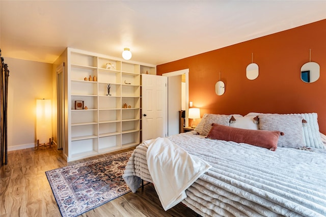 bedroom with baseboards and wood finished floors