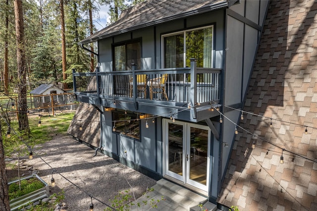 back of property featuring french doors, a patio, and a shingled roof