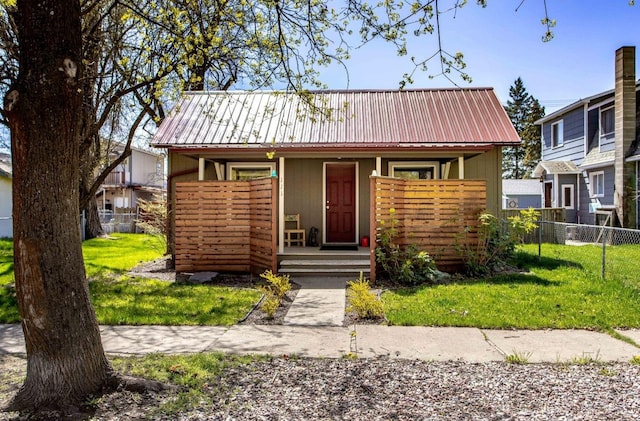 111 6th Ave W, Polson, MT 59860 - bungalow featuring a front lawn, fence, covered porch, and metal roof