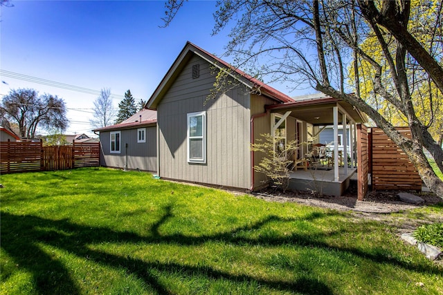 111 6th Ave W, Polson, MT 59860 - rear view of property featuring fence, a yard, a patio area, and metal roof