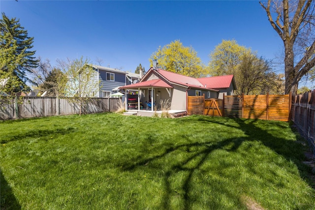 111 6th Ave W, Polson, MT 59860 - back of property featuring a fenced backyard, a yard, and metal roof