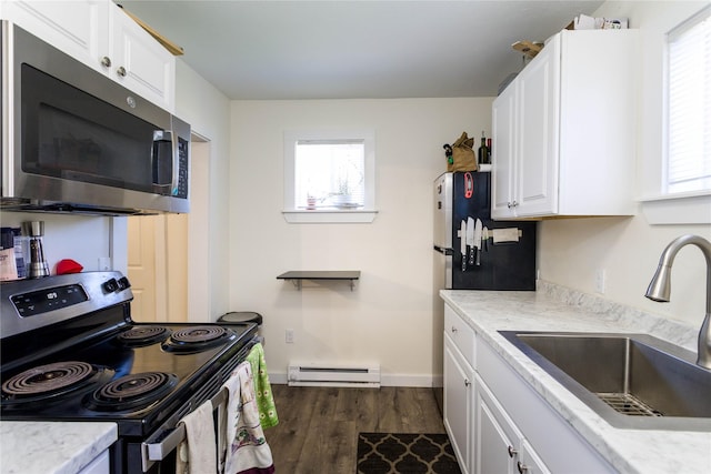 111 6th Ave W, Polson, MT 59860 - kitchen featuring white cabinets, a sink, dark wood finished floors, stainless steel appliances, and a baseboard heating unit