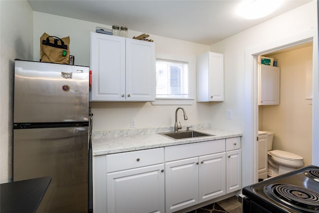 111 6th Ave W, Polson, MT 59860 - kitchen featuring freestanding refrigerator, white cabinets, black electric range, and a sink