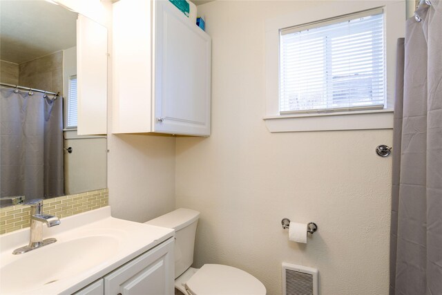 111 6th Ave W, Polson, MT 59860 - full bathroom featuring vanity, heating unit, toilet, a shower with shower curtain, and tasteful backsplash